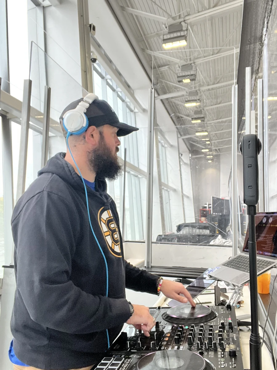 Kyle working at the DJ decks in a hockey venue