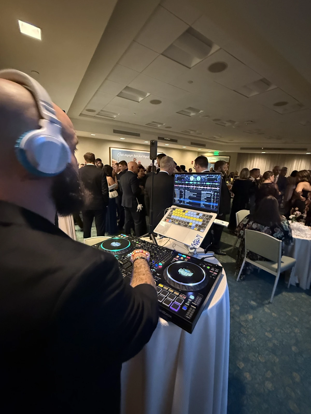 Kyle in headphones performing for guests at an indoor reception